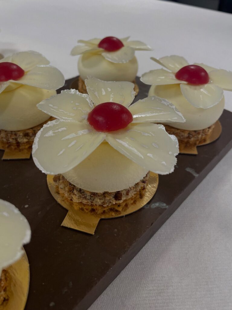 Bakelser med blomblad av vit choklad och röd mitt