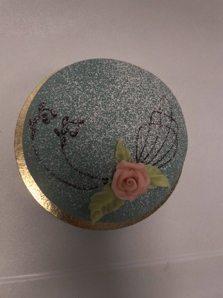 Turkos tårta med rosa marsipanros och chokladdekor